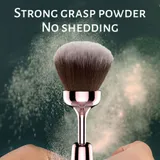 Cosmetic Pen brush-head close-up surrounded by loose makeup powder against a dark green background
