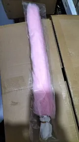 Pink faux fur tail product inside a clear supplier sleeve on cardboard, separate from delivery outer packaging