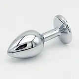 YB26 anal plug lying diagonally on white, with its tapered tip to the left, round base to the right and reflective silver-coloured surface