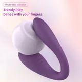 Purple Whale tide vibrator showing its curved two-arm shape against white decorative spheres